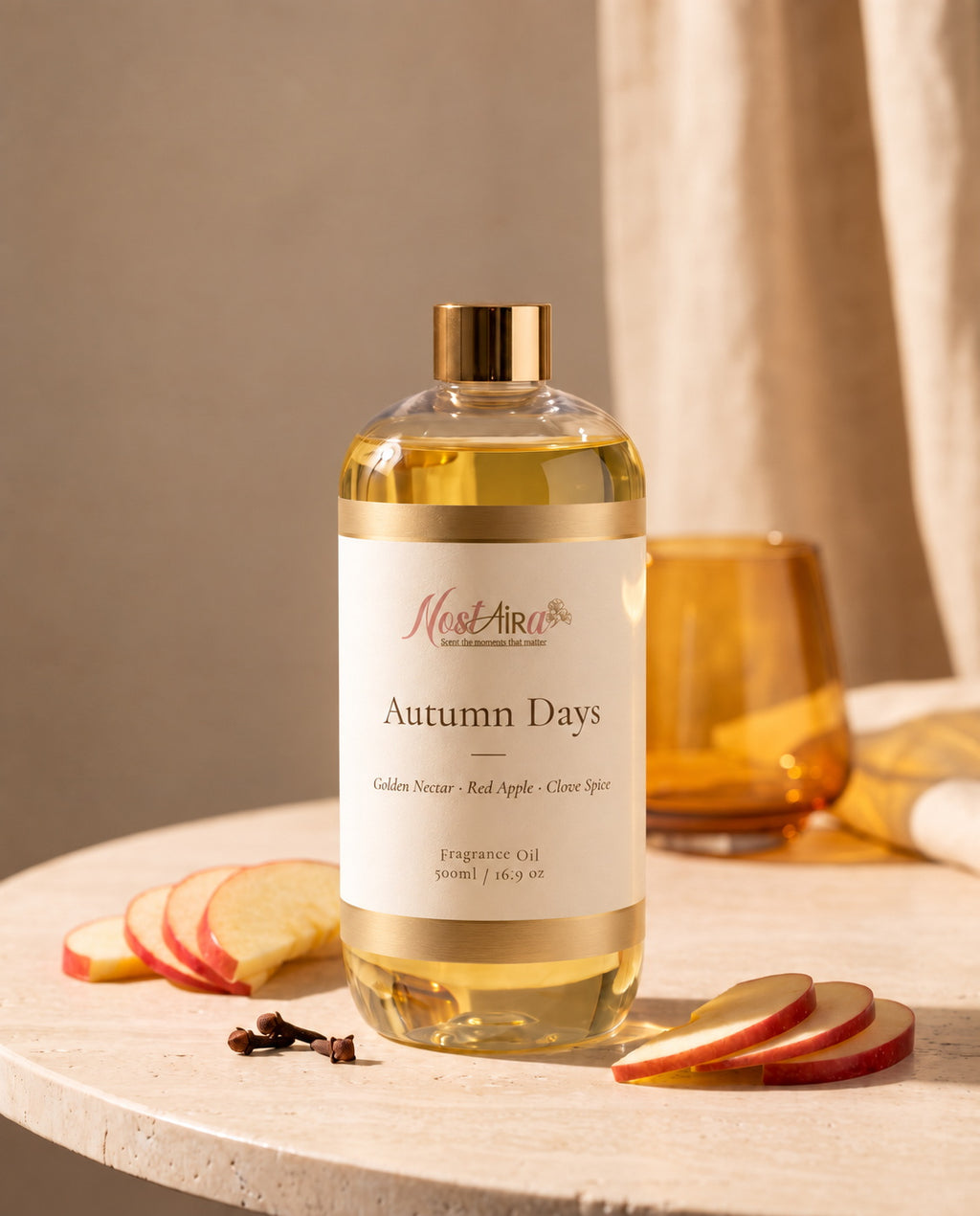 Autumn Days 500ml fragrance oil on a stone table with sliced red apple, clove and an amber glass
